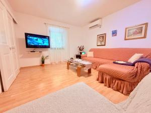 a living room with a couch and a flat screen tv at House Rukavina in Bakarac