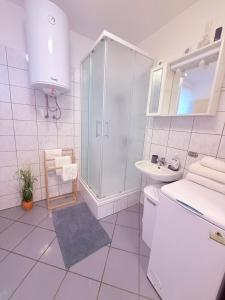 a white bathroom with a shower and a sink at House Rukavina in Bakarac +18 photos