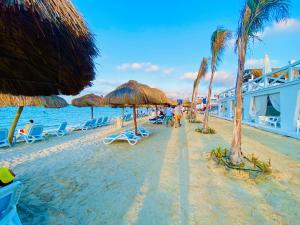 a beach with umbrellas and chairs and the ocean at Porto marina Panoramica sea view in front marina 2 in El Alamein