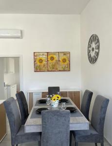 Una mesa de comedor con sillas y un reloj en la pared. en Villa PO, en Torre Santa Sabina 23 fotos más