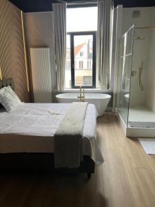a bedroom with a bed and a bath tub and a window at 8Z Dreamz 3 in Ghent