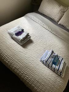 a bed with towels and a razor and a cell phone at Daisy-Jacks Hideaway in Briery Yards