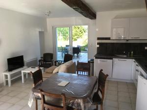 a kitchen and a living room with a table and chairs at Le village caché in Le Mayet-de-Montagne