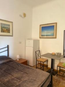 a room with a table and a refrigerator and a table and chairs at Il Nido Al Mare ROOM by 5TR Apartments in Levanto