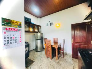 a kitchen with a table and a calendar on the wall at R Homes in Ja-Ela