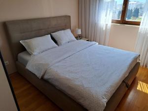バールにあるStan u centru BEST VIEWのベッドルーム1室(白いシーツが敷かれた大型ベッド1台、窓付)