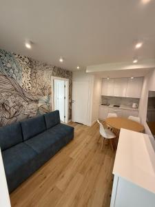 a living room with a blue couch and a table at Apartamenty Solano - wybrane z widokiem na morze in Rowy