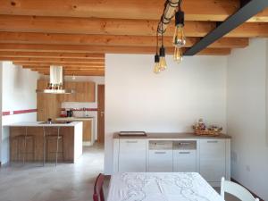 a kitchen with white walls and a wooden ceiling at Luce del Mattino in San Vito al Tagliamento