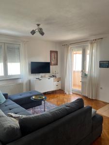 a living room with a couch and a tv at Apartment Sunny day in Livno