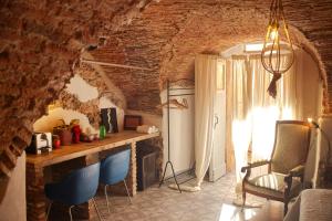 - un salon avec un mur en briques, une table et des chaises dans l'établissement Vale's Gardens at Borgio Verezzi, à Borgio Verezzi