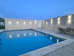 a swimming pool at night with a table and chairs at Anturios House Apartamento 2 in San Marcos