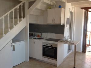 a kitchen with white cabinets and a staircase at Amalia Harbor in Halki +13 photos