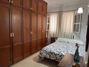 a bedroom with a bed and some wooden cabinets at CASA ENTERA PLAYA PUERTO del ROSARIO in Puerto del Rosario
