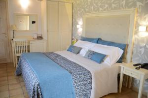 a bedroom with a large bed with blue and white sheets at Artemisia Resort in Puntarazzi