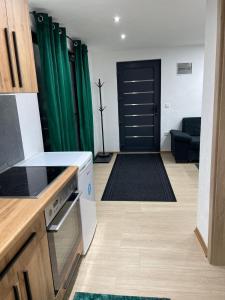a kitchen with a door and a living room at Apartman Flora Vlasic in Vlasic +6 photos