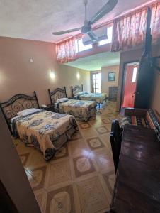a bedroom with two beds and a ceiling at Hotel Hacienda Prom in Misantla