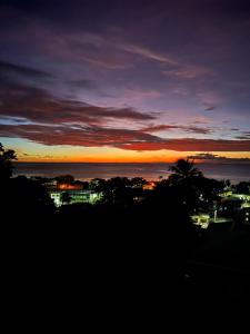 a view of a sunset with a city and the ocean at D View Cozy Corner in Gouyave