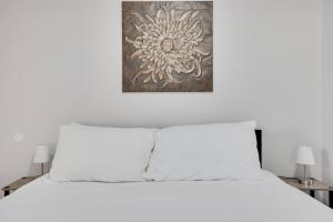 a white bed with two pillows and a picture above it at Close to Hospitals with W&D Free Parking Fast Wifi in Wilkes-Barre