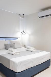 a white bed with two towels on top of it at GeoMar Luxury Apartments in Skala Marion