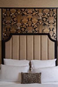 a bed with a black and gold headboard and white pillows at Hotel Experior Boutique - Destigo Hotels in Kraków