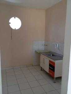 a white kitchen with a sink and a counter at Apartamento 02 Quartos São João de Jequié in Jequié