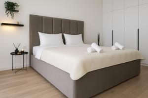 a bedroom with a large bed with white sheets at Belgrade Waterfront Nomad Luxury Apartments in Belgrade