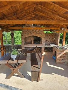 a picnic table under a pavilion with a brick fireplace at Apartment JB2 Grmovine in Risika