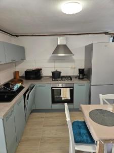 a kitchen with a stove and a table in it at Apartment JB2 Grmovine in Risika +12 photos