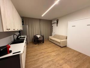 a kitchen and living room with a couch and a table at Casa al Mare Civitanova Marche in Civitanova Marche