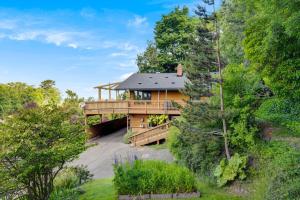 a house with a large deck in the woods at Four Seasons Cabin, ONP, Olympic Trail, Hot-tub in Port Angeles