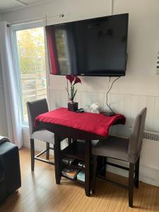 mesa de comedor con mantel rojo y TV en Chez Mayan et Doly, en Clarke City