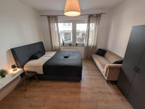 a small bedroom with a bed and a couch at Stilvolle Ferienwohnung am Paderquellgebiet mit Terasse in Paderborn