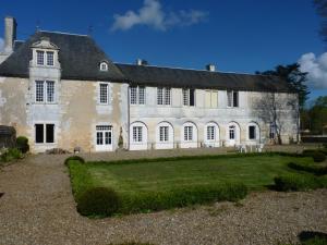 Bignoux的住宿－LOGIS du Château du Bois Doucet，一座古老的石头建筑,前面有一个草地庭院