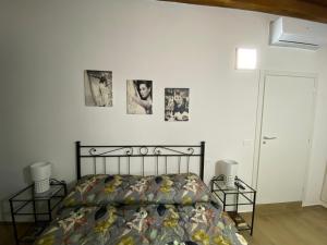 une chambre avec un lit et des tableaux au mur dans l'établissement La Casa sul Corso, à Ascoli Piceno