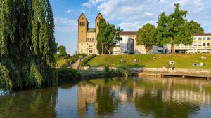 a building with a tower next to a body of water at Stilvolle Ferienwohnung am Paderquellgebiet mit Terasse in Paderborn