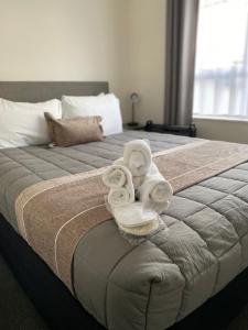 ein Schlafzimmer mit einem Bett mit Handtüchern darauf in der Unterkunft Parkside Cottage in Napier