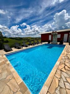 une piscine avec des chaises et une maison dans l'établissement A Casinha, à Socorro