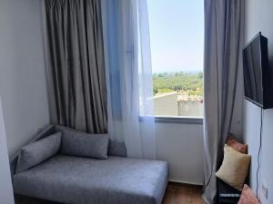 a room with a couch next to a window at Amantius Apartments Borsh Himare in Borsh