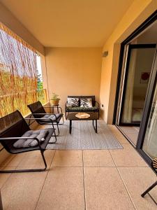 a living room with a couch and chairs on a balcony at T2 neuf Parking privé Balcon Plages à 15 min in Montpellier