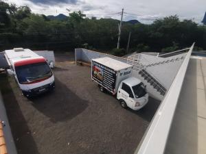 a truck and a white car parked next to a building at Apartamento 04 Centro de Igrejinha in Igrejinha