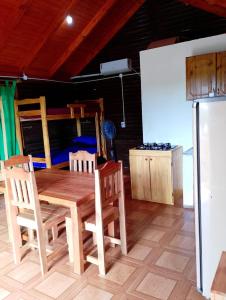 a wooden dining table and chairs in a room at CABAÑAS Gaucho RIVERO in El Soberbio