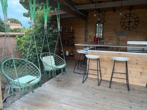 a porch with chairs and a bar on a deck at La Villa Catalane in Bompas
