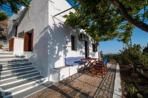 Maison blanche avec 2 chaises et une table dans l'établissement CasaLindos Spitaki, à Lindos