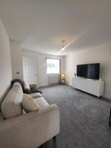 ein Wohnzimmer mit Couch und Flachbildfernseher in der Unterkunft Bright & Spacious 3-Bed Rotherham Home Ideal for Families or Contractors in Kimberworth