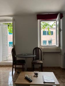 a dining room with a table and two chairs and a window at Hidden Gem Studio Apartment in Herceg-Novi
