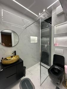 ドゥラスにあるGimi Premium Apartmentsのシャワー、トイレ、洗面台を備えたバスルーム