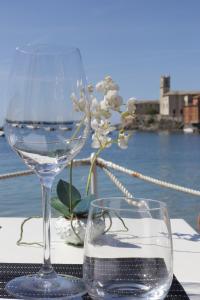 a wine glass sitting on top of a table with a flower at Hotel Miramare & Spa in Sestri Levante