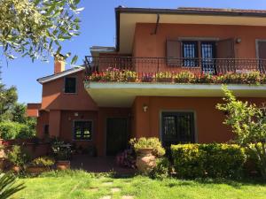 une maison orange avec des fleurs sur le balcon dans l'établissement B&B Le Querce, à Formello