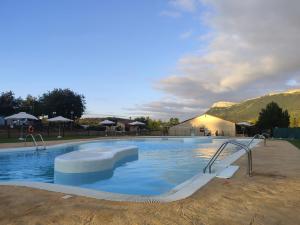 a large swimming pool with blue water at Camping Cantabria in Polientes