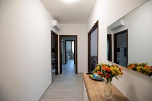 a hallway with a vase of flowers on a table at Barbieri Suite - Green, Relaxation and Comfort in Modena +35 photos
